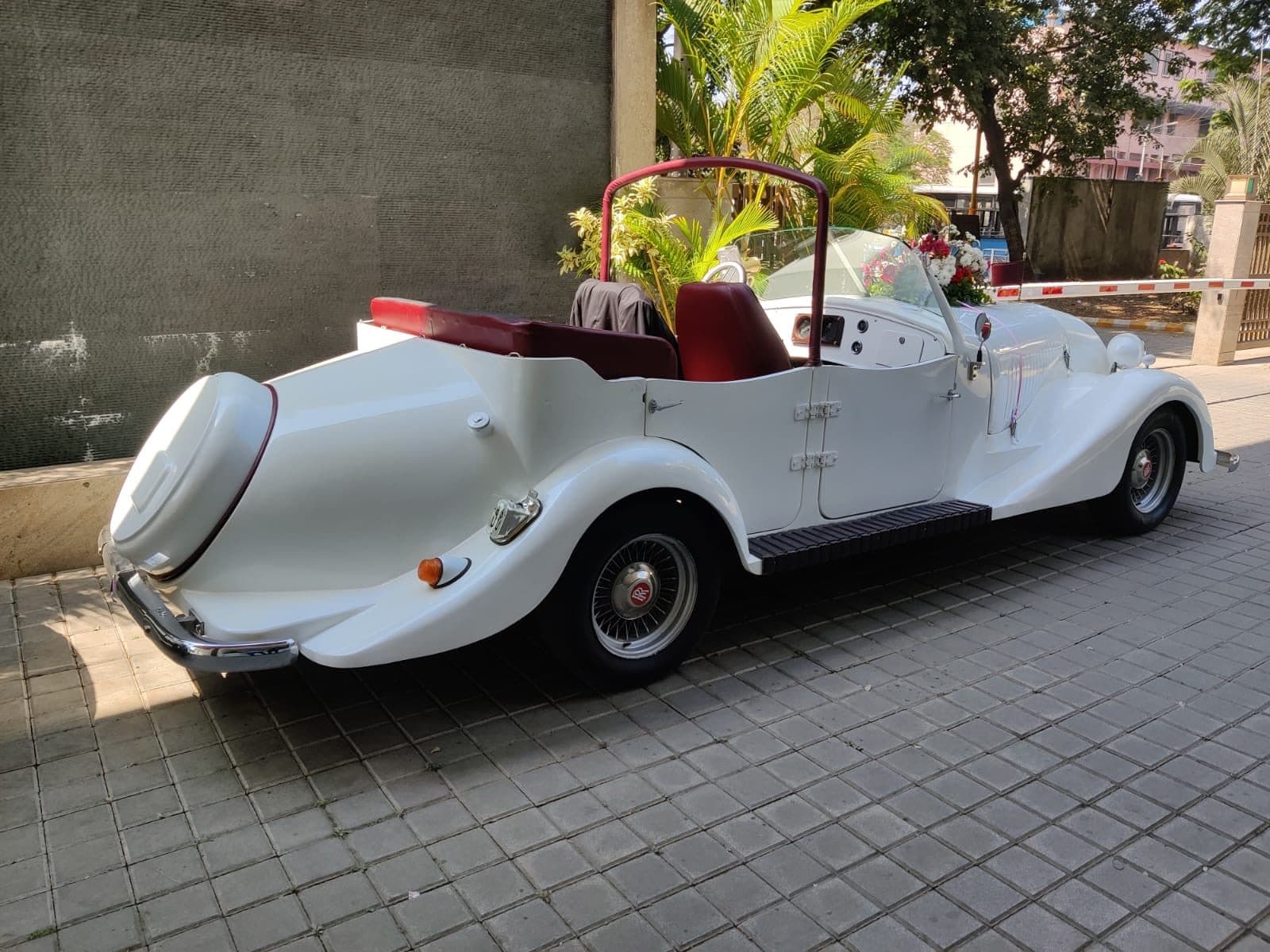 Vintage white convertible decorated with flowers for a wedding entry