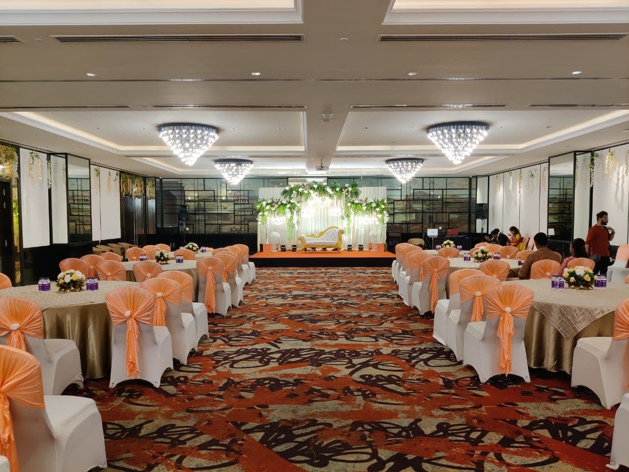 Banquet hall set with covered chairs and sashes for a corporate dinner